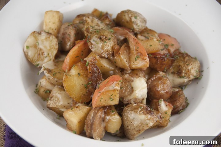 A close-up shot of the Potato, Apple, and Chicken Sausage Bake, fresh from the oven, topped with perfectly melted cheese. This hearty dish is ideal for breakfast, lunch, or dinner, promising delightful flavors.