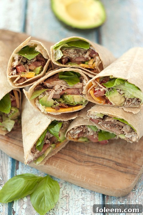 Hearty and fresh 15 Minute Avocado Caprese Chicken Wraps featuring balsamic chicken, avocado, and fresh vegetables in whole wheat tortillas.
