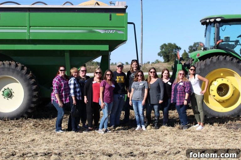 Group photo of participants at Kenney Farm in Iowa, standing in front of a combine harvester.