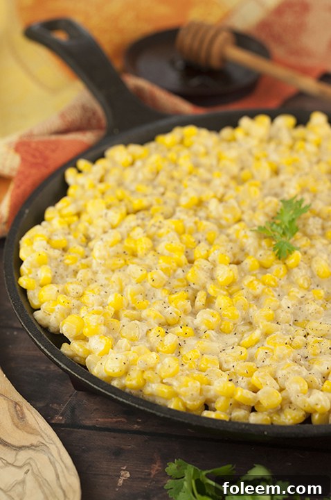 Honey Butter Creamy Skillet Corn garnished with fresh herbs, ideal for any dinner table