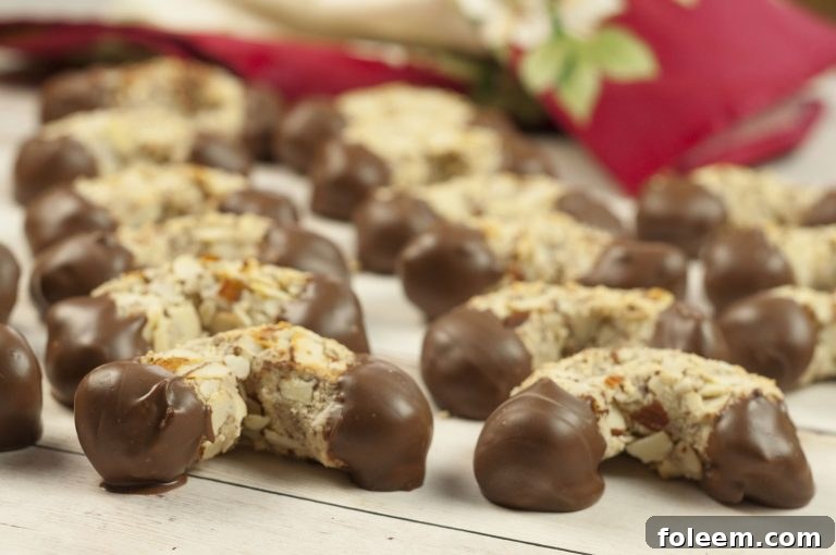 Grandma's Traditional Italian Chocolate-Dipped Almond Horns recipe - horseshoe-shaped crescent cookies that are moist and chewy on the inside with a crunchy almond texture on the outside, presented alongside other Italian treats.
