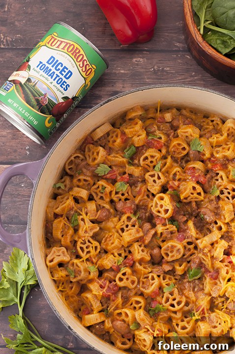 One Pot Chili Mac and Cheese cooking on the stovetop with a rich, tomato-based sauce and pasta.