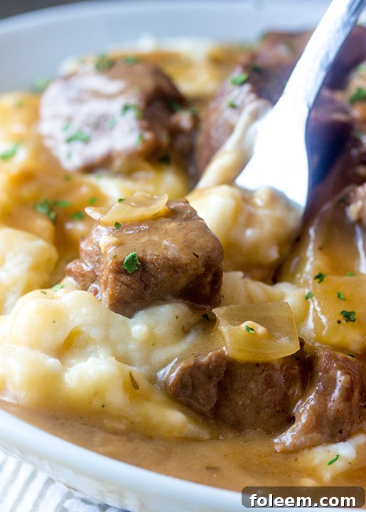 Tender Slow Cooker Beef Tips and Gravy served over creamy mashed potatoes, perfect for a cozy weeknight dinner or impressive holiday meal.