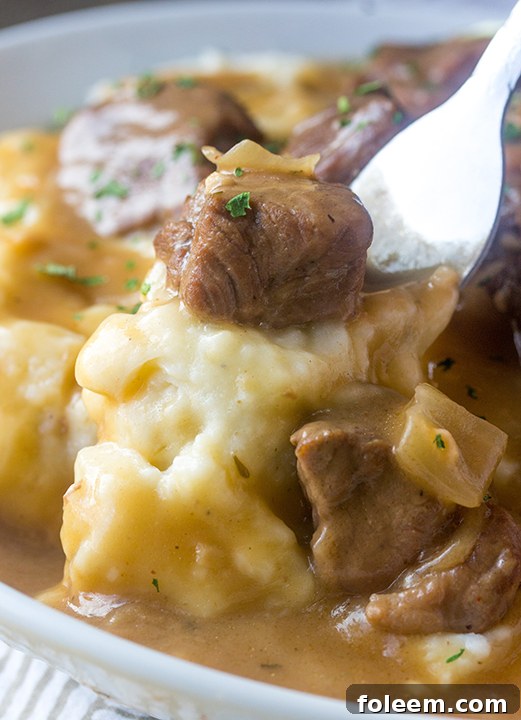 Slow Cooker Beef Tips and Gravy, effortlessly prepared in a crock pot, served over a bed of rice or pasta, ready to enjoy.