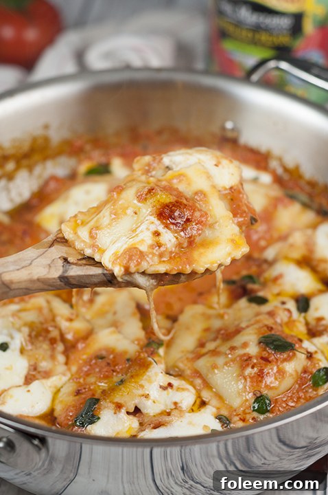 A close-up shot of a skillet brimming with freshly cooked Ravioli al Pomodoro, highlighting the rich, simmering tomato sauce and perfectly melted fresh mozzarella. An ideal easy and flavorful Italian dinner solution.