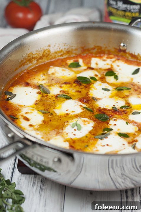 A tantalizing skillet of Ravioli al Pomodoro, beautifully garnished with fresh mozzarella and basil, exuding the appeal of a restaurant-quality Italian meal achieved effortlessly with San Marzano tomatoes.