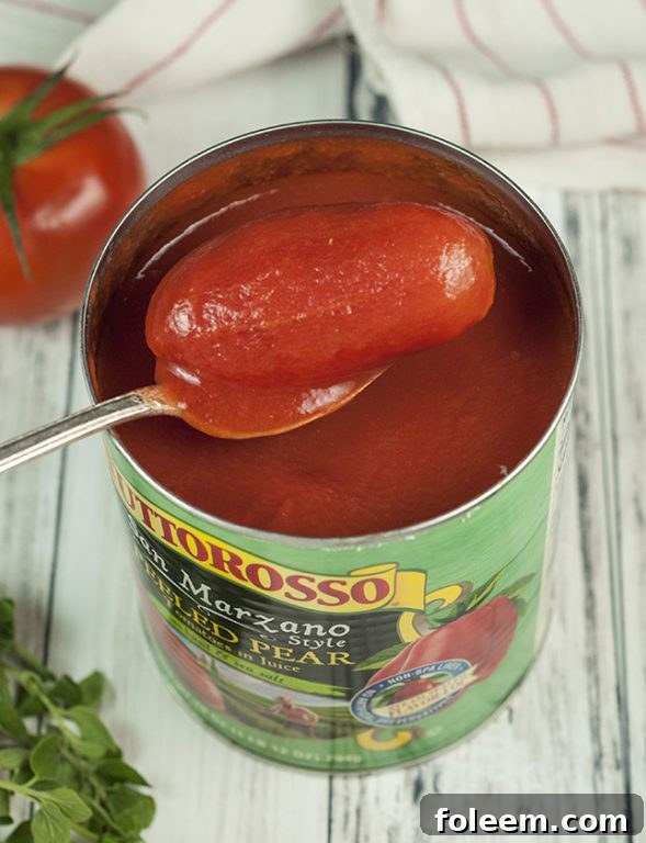 A pristine can of Tuttorosso San Marzano Style Pear Tomatoes, prominently labeled with basil and sea salt, signifying premium quality ingredients vital for authentic Italian cooking.