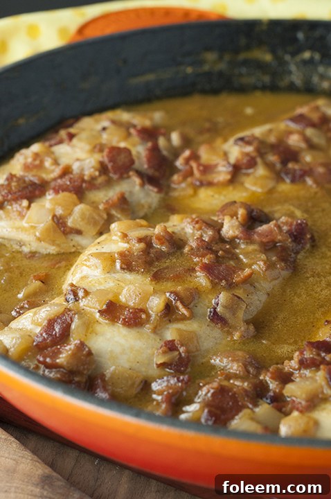 Generous serving of Maple Mustard Bacon Chicken Skillet on a plate, showcasing the creamy sauce, tender chicken, and visible bacon pieces, ready to be enjoyed.