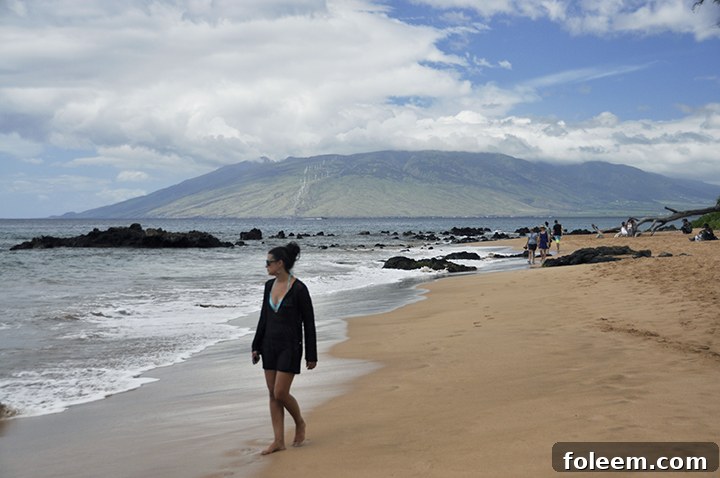 A person enjoying a leisurely walk on the beach at the Hyatt Regency Maui in Hawaii.