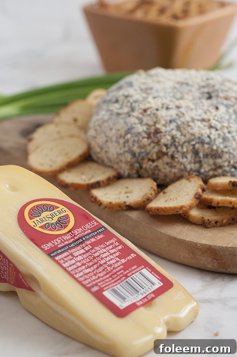 Close-up of a festive Everything Bagel Cheese Ball, generously coated in seasoning, ready to be enjoyed at a holiday party.