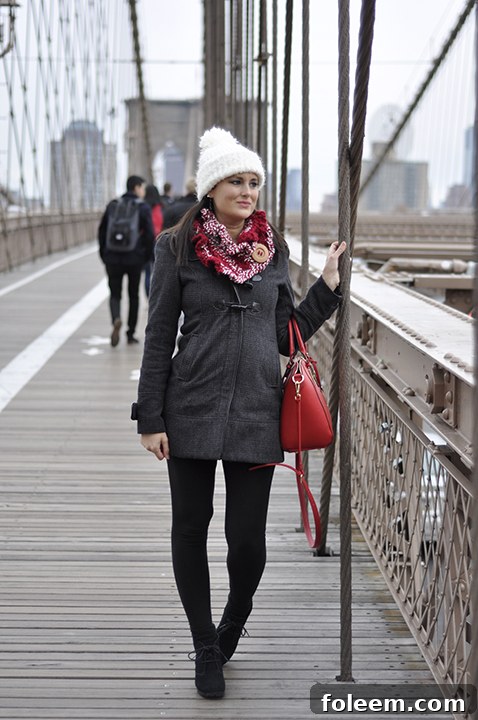Photo walking across the Brooklyn Bridge in NYC at 12 weeks pregnant, offering stunning views of the Manhattan skyline.