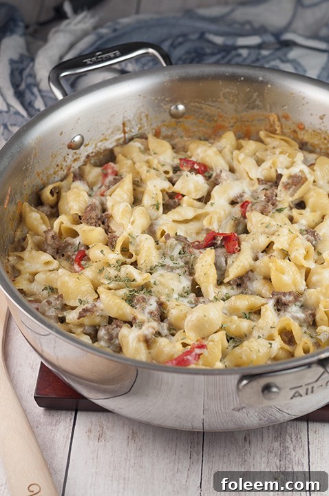 A large baking dish filled with bubbling, golden-brown Philly Cheesesteak Pasta, ready to serve.