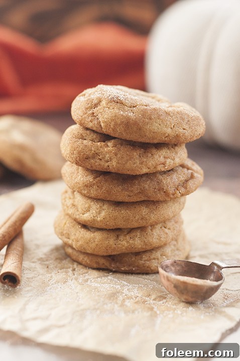 Soft, fluffy Pumpkin Snickerdoodles piled high on a serving plate, dusted with cinnamon sugar, perfect for a fall treat or holiday dessert.