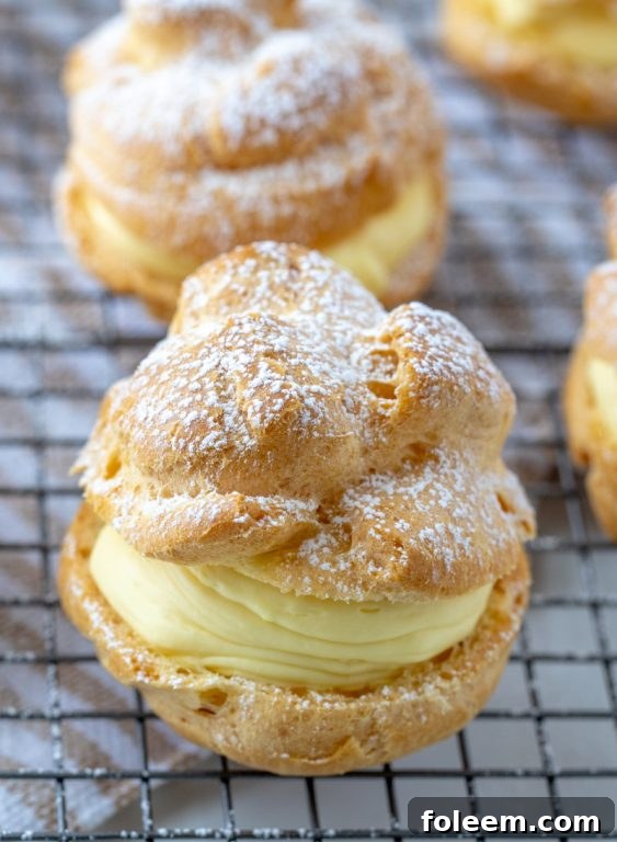 Freshly baked cream puffs on a wire rack, ready for filling