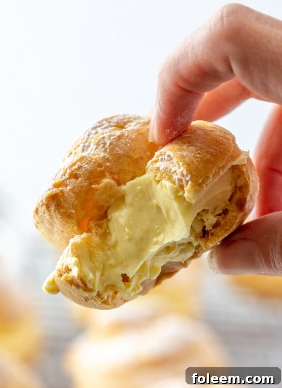 Three homemade cream puffs arranged elegantly on a serving plate