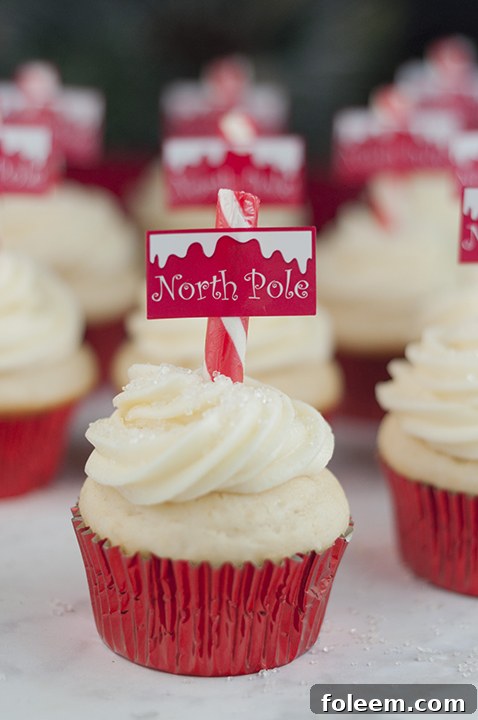 Snowy North Pole Cupcakes adorned with white frosting, sprinkles, and candy cane poles, a perfect festive treat for Christmas.
