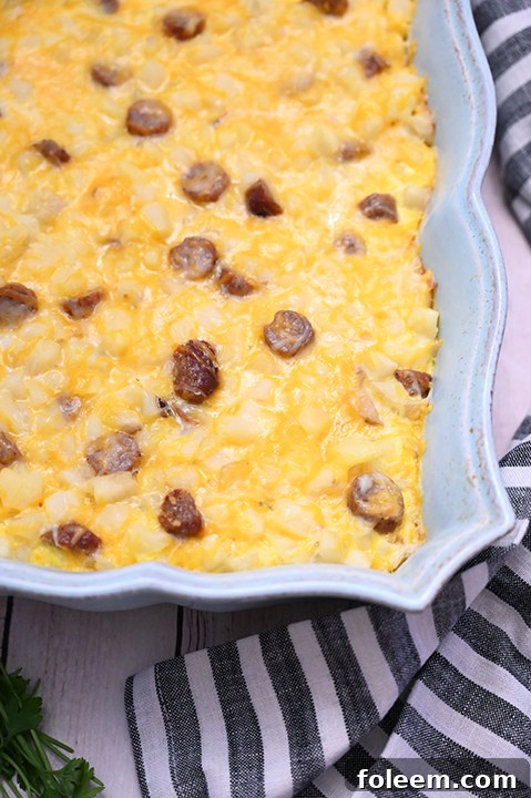 A slice of Cheesy Potato Sausage Breakfast Casserole on a plate, ready to be enjoyed.