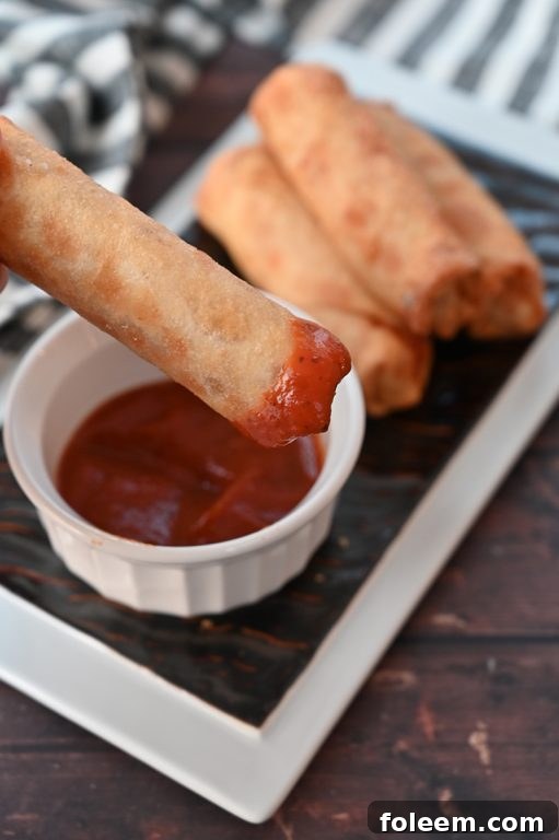 Golden brown baked pepperoni pizza rolls served with a side of pizza sauce