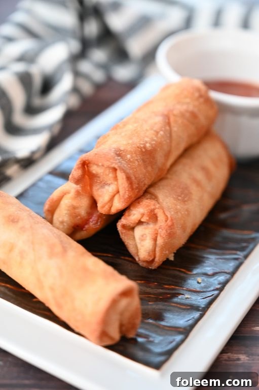Two hands holding a perfectly baked pepperoni pizza roll, ready to be dipped