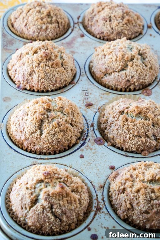 Close-up of fluffy banana muffins adorned with a generous brown sugar crumb topping, ready to be enjoyed.