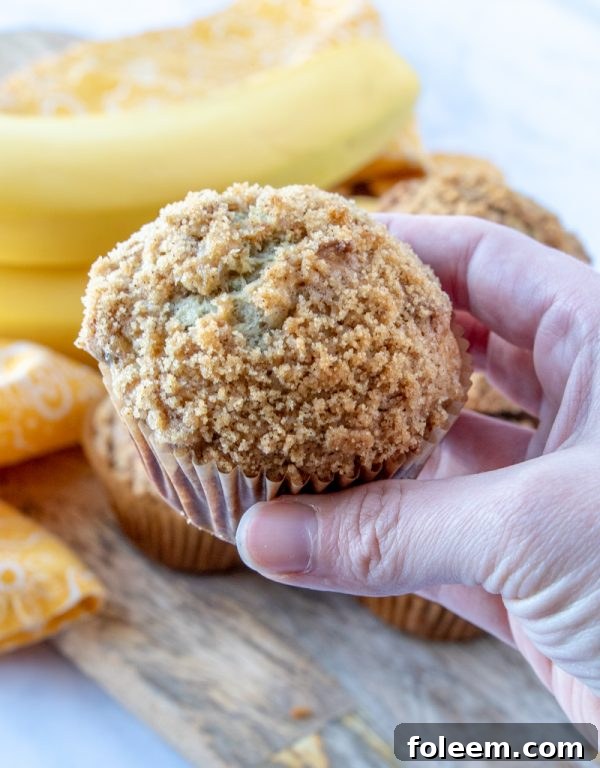 A batch of homemade banana crumb muffins cooling on a wire rack, showcasing their perfect dome and inviting streusel.