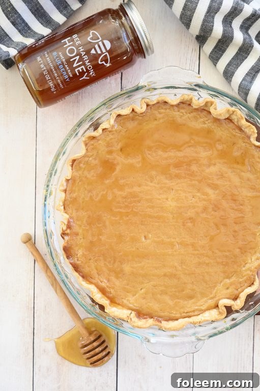 Close-up of a slice of Salted Honey Pie showing its creamy custard filling and a golden brown crust, ready to be served