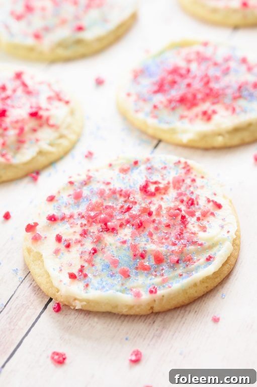 Close-up of easy Frosted Firecracker Pop Rocks Cookies, showcasing red and blue pop rocks on white frosting