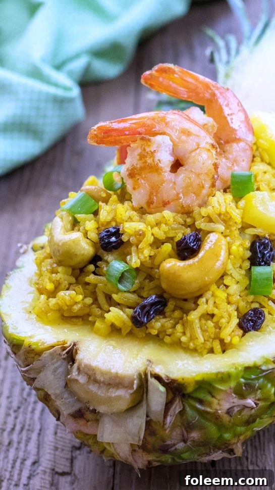 Close-up shot of a vibrant bowl of Pineapple Shrimp Fried Rice, highlighting the succulent shrimp, golden rice, and fresh ingredients.