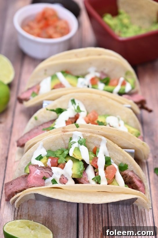 Grilled Flank Steak Tacos with creamy avocado and zesty cilantro lime crema.