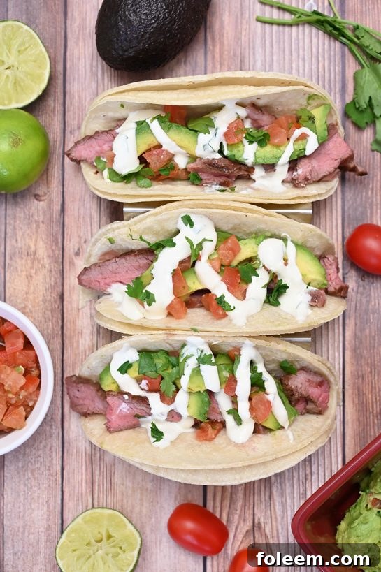 Medium-rare Grilled Flank Steak Tacos with creamy avocado and zesty Cilantro Lime Crema.