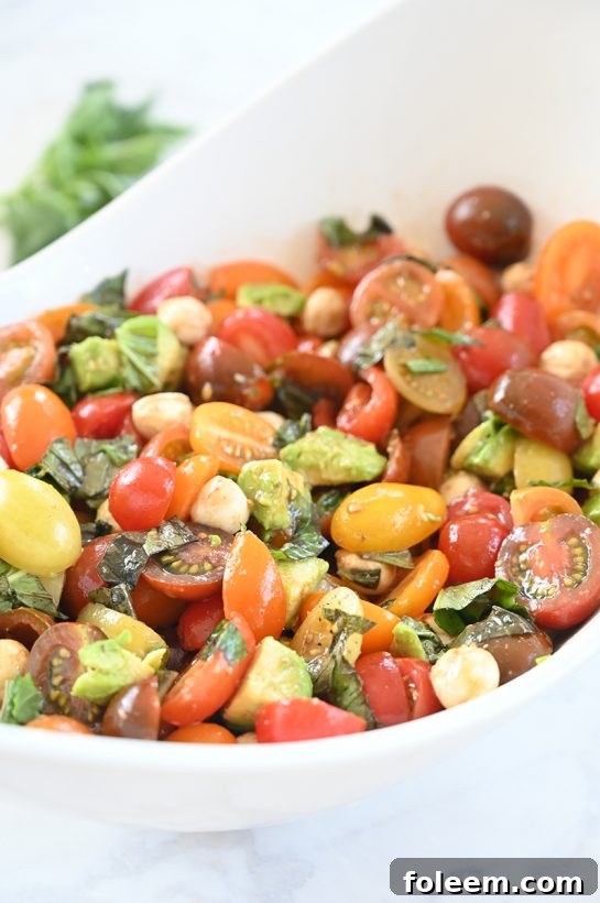 Light, refreshing, healthy Caprese Avocado Salad recipe packed with fresh mozzarella cheese is a quick and easy side dish idea in a salad! This is great for any picnic, holiday, or BBQ!