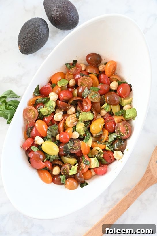 Light, refreshing, healthy Caprese Avocado Salad recipe packed with fresh mozzarella cheese is a quick and easy side dish idea in a salad! This is great for any picnic, holiday, or BBQ!