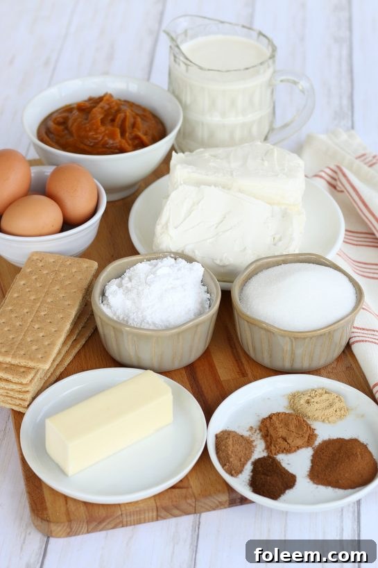 All the ingredients to make Pumpkin Cheesecake Bars, including graham cracker crumbs, sugar, butter, cream cheese, ground cinnamon, ground ginger, ground cloves, eggs, pumpkin puree, ground nutmeg, pumpkin pie spice, heavy whipping cream, and powdered sugar.