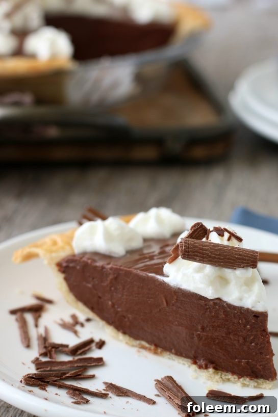 A tantalizing close-up shot of a perfect slice of old-fashioned chocolate pie, highlighting its rich, dark filling and delicate crust, ready for indulgence.