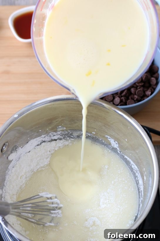 A captivating image showing wet ingredients being expertly whisked into the rich, developing old-fashioned chocolate pie batter, illustrating a key stage in the recipe.