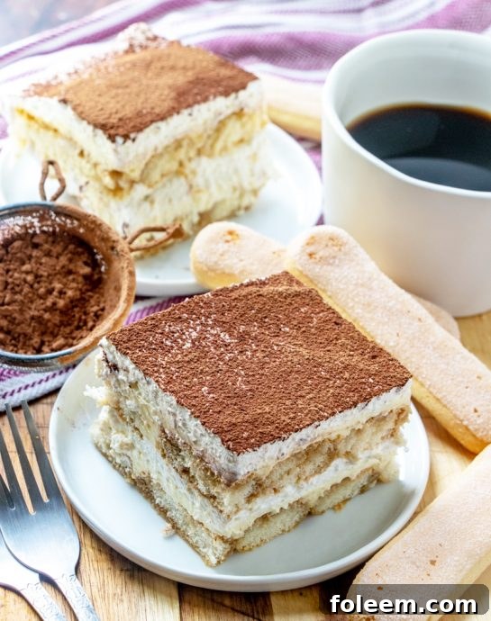 A close-up shot of the finished Tiramisu, generously dusted with cocoa powder, showing its inviting texture.