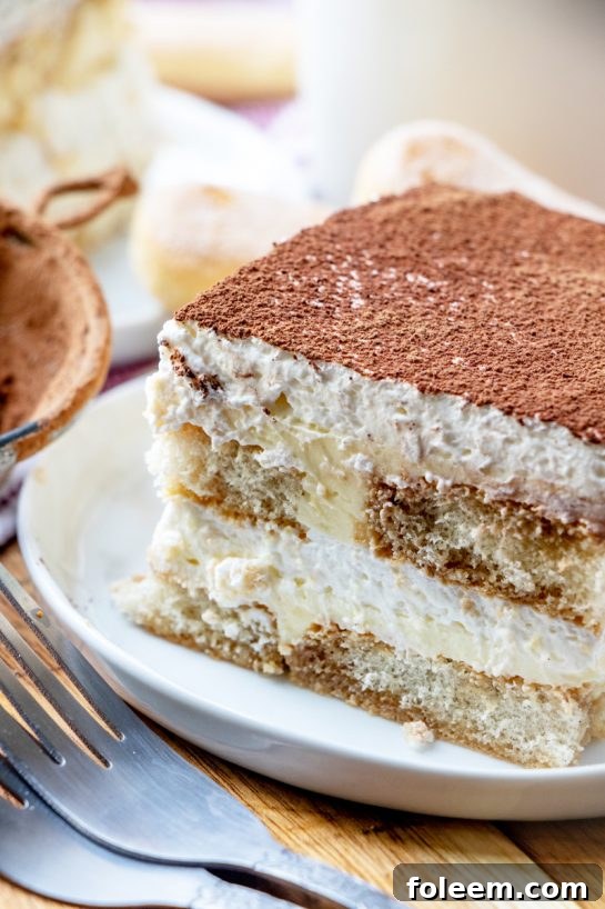A full Tiramisu in a glass dish, viewed from above, ready for slicing and serving at a festive gathering.