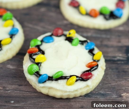 Close-up of freshly baked Christmas Light Bulb Cookies, showing vibrant M&M's and simple black icing lines, perfect for easy decorating without royal icing.