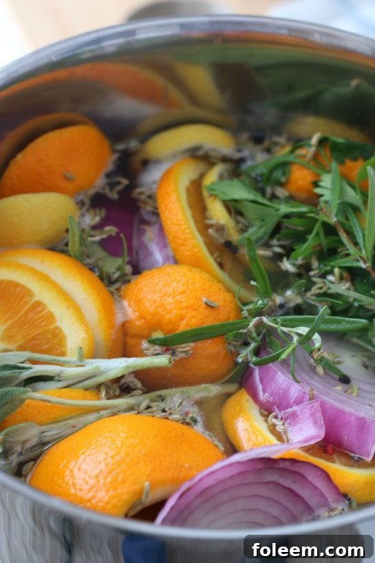 Water is added to the simmering turkey brine ingredients, now mixing together before submerging the turkey.