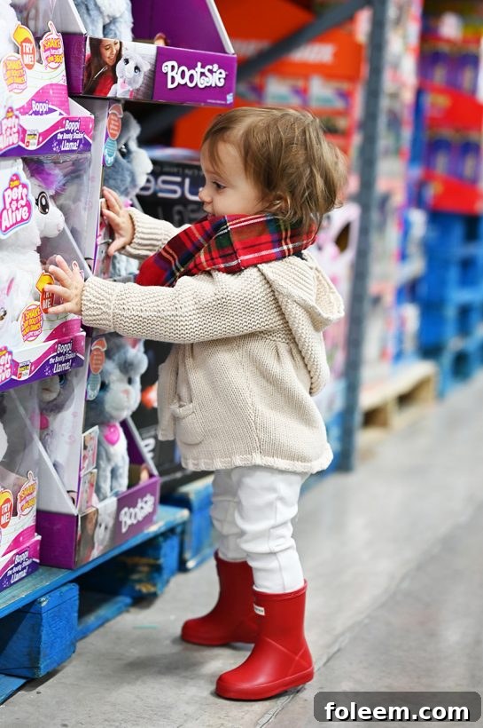 Child happily browsing for toys in the toy aisle at BJ's Wholesale Club during holiday shopping