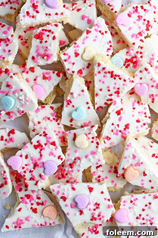A top-down view of the cookie bark, expertly finished with sprinkles and conversation hearts, neatly broken into inviting pieces and ready to be served.