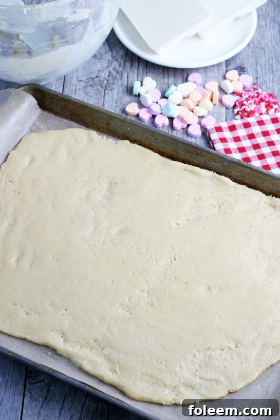 Here is a great sugar cookie dough idea, illustrating the simple and quick process of rolling or pressing the sheet of cookie dough out thin onto a baking sheet, ensuring even baking.