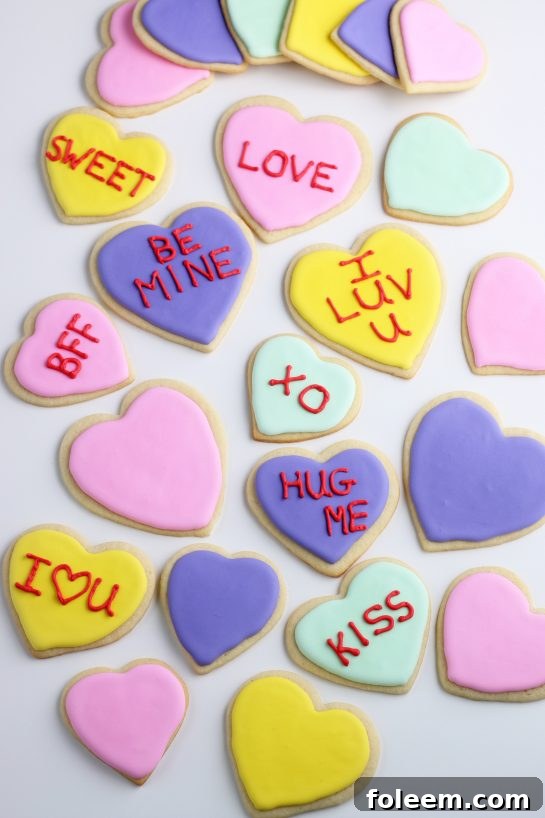 An overhead view showcasing a collection of finished Valentine's Day conversation heart cookies, demonstrating easy and fun sugar cookie decorating ideas.