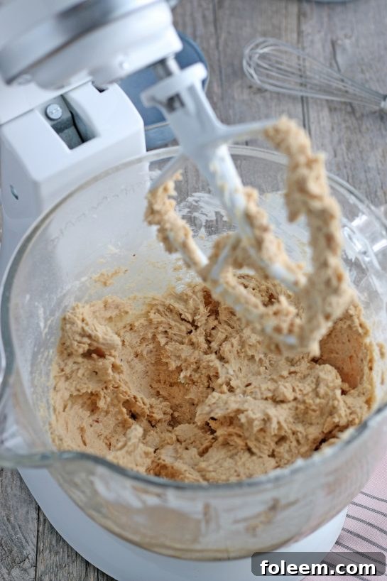 A glimpse into the mixer as the batter for the Linzer tart cookies is being created, showing a smooth and well-incorporated mixture.