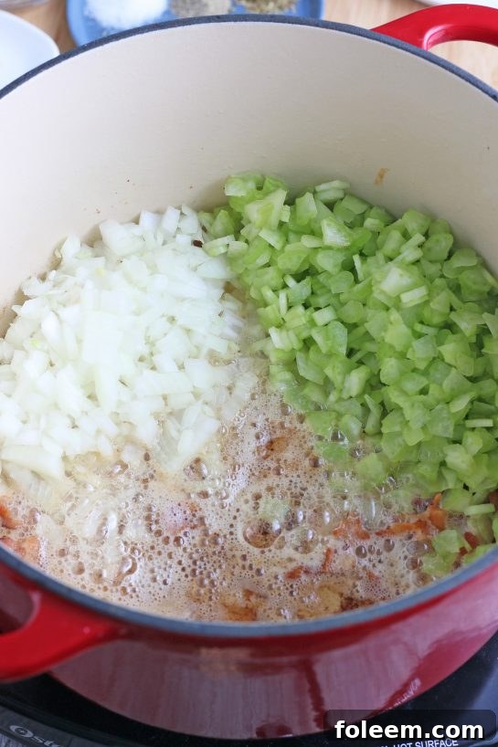 Here we see the vegetables being added to the pot so they can begin cooking and absorbing flavors for the homemade clam chowder.