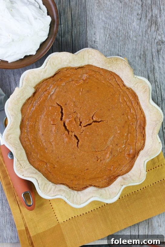 A beautifully baked whole sweet potato pie, golden brown and ready to be sliced and served.