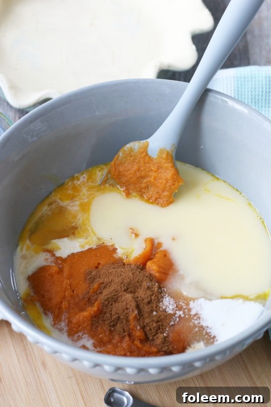 A large mixing bowl filled with the vibrant orange sweet potato pie filling ingredients, ready to be combined.