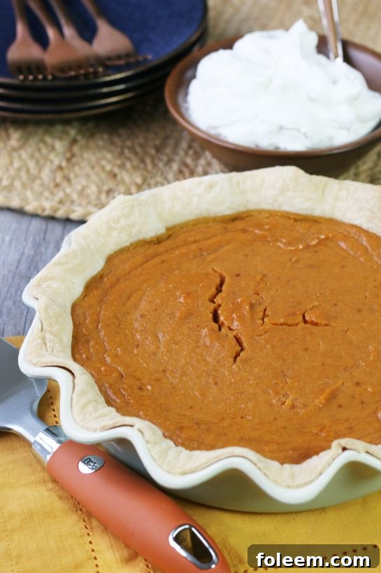 A stunning, perfectly baked sweet potato pie cooling on a wire rack, appearing almost too delicious to eat.