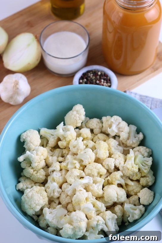 Cauliflower florets perfectly cut and arranged in a bowl, ready to be tossed with olive oil and spices before roasting for the soup recipe.