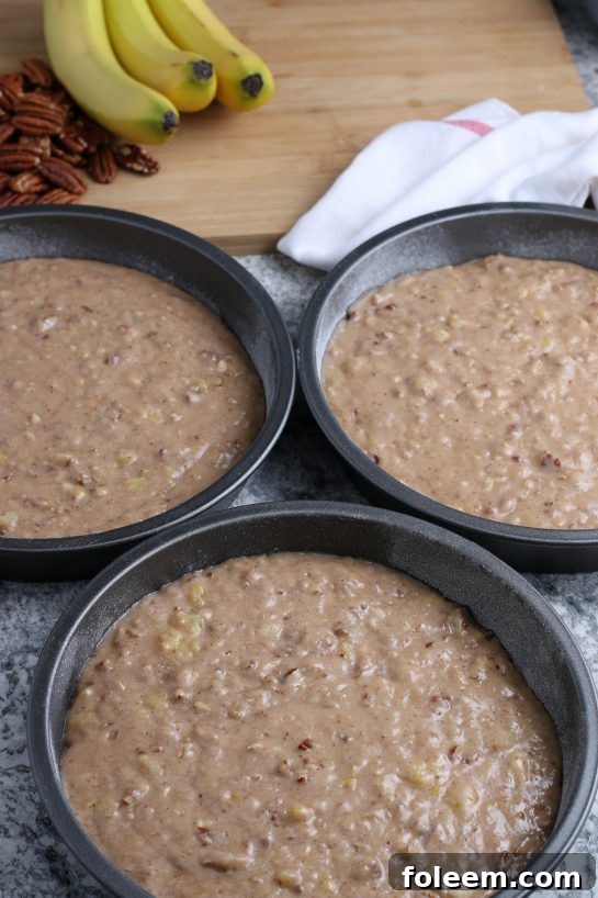 Pouring the cake batter into the cake pans for the Homemade Hummingbird Cake recipe